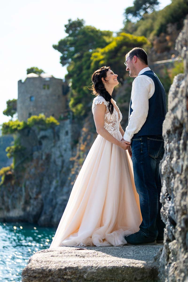 Newlyweds standing next to each other while taking pictures together during a Positano wed photography session