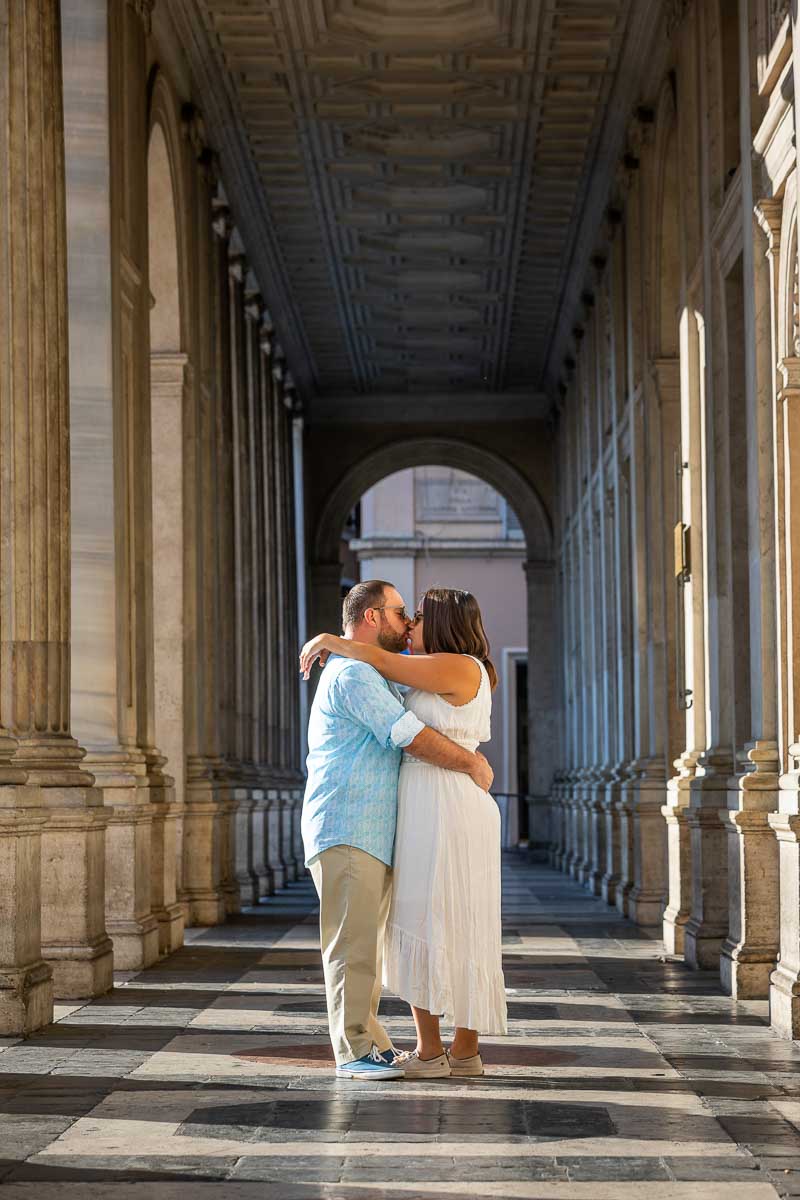Couple kissing under the portico found on the side of Monte Citorio in Rome Italy
