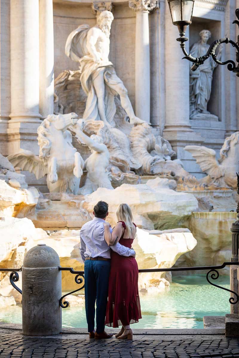 Watching the Trevi fountain from above couple looking in