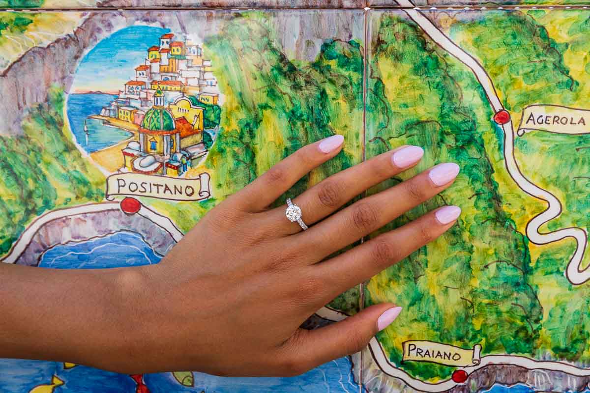 Close up of the engagement ring posed in front of the Positano ceramic map. Surprise Proposal in Positano