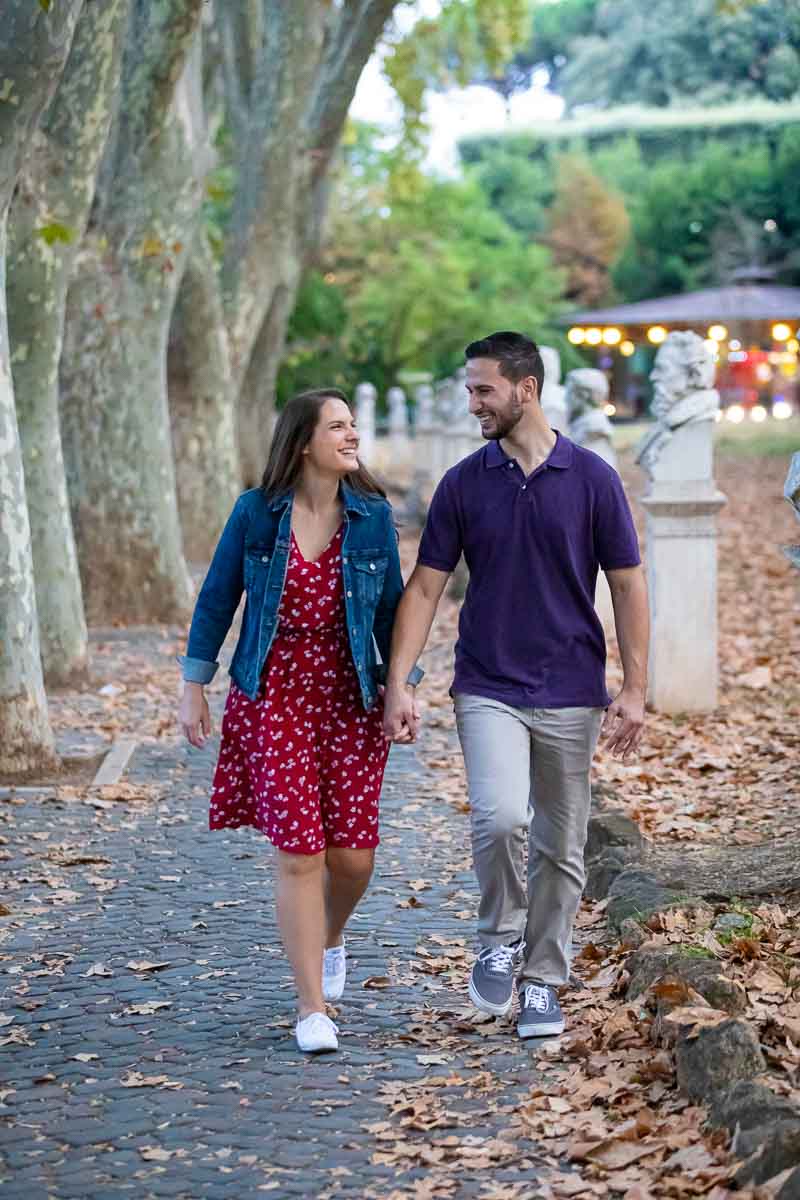 Walking together in the roman streets with high and old oak trees on the side road