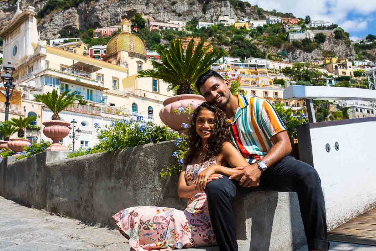 Couple posing while sitting down in the center of town after a Surprise Proposal in Positano Italy 