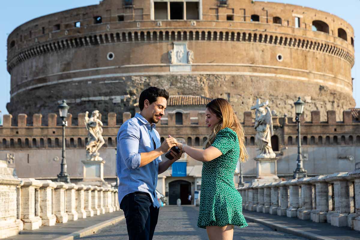 Putting on the engagement ring on the finger after popping the big question. Couple portrait image closeup