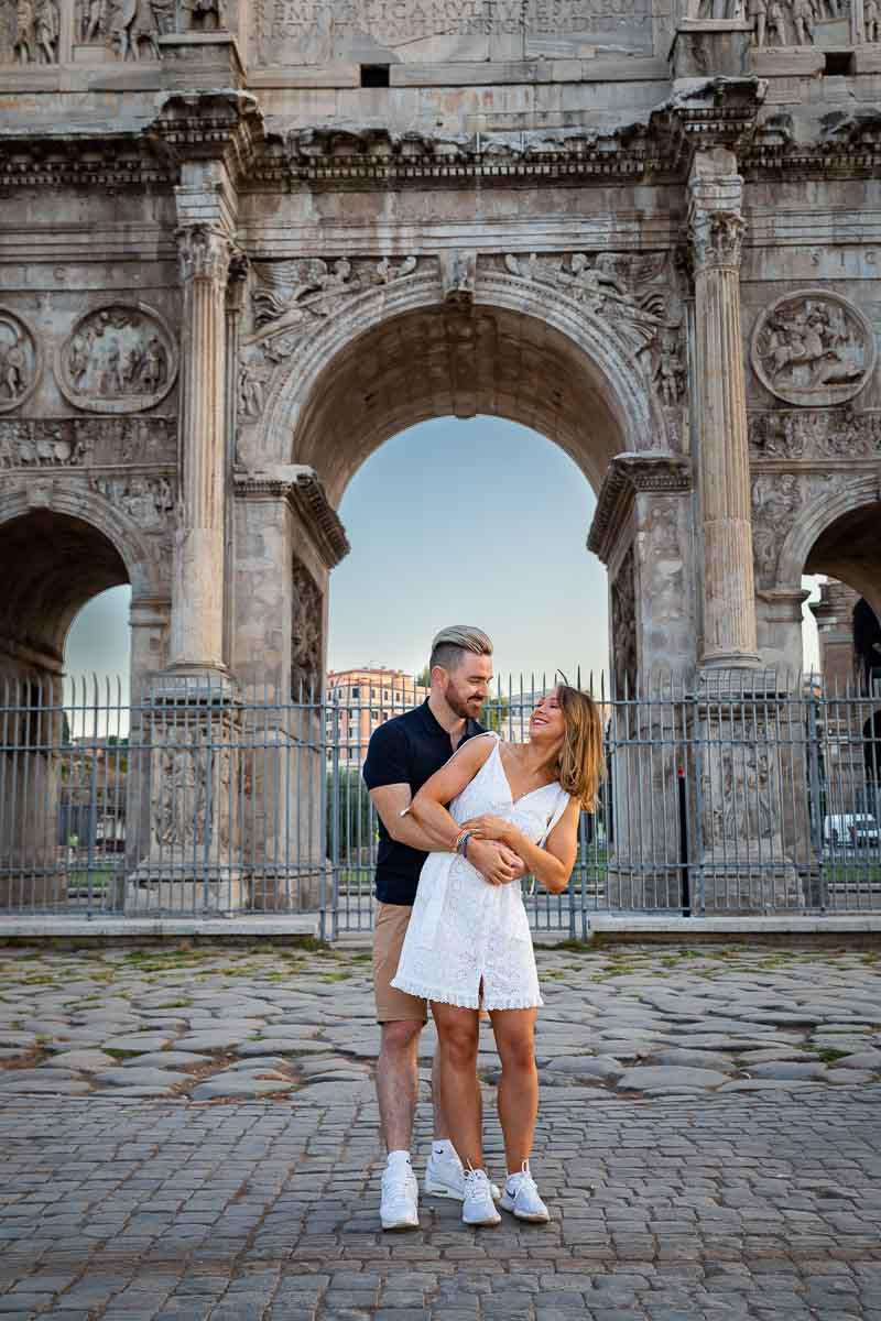 Couple portrait picture standing before the arch of Constantine in Rome Italy
