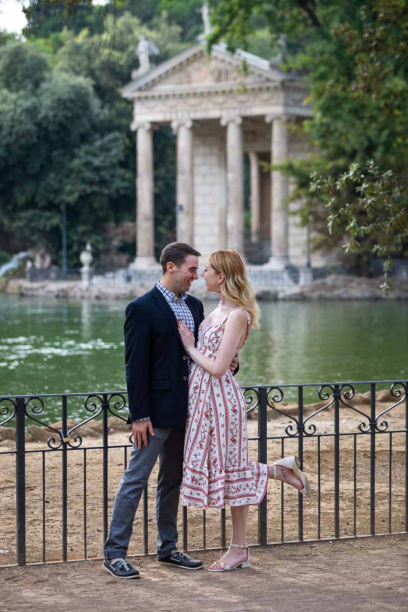 Couple in love inRome before the ancient temple in the middle of the borghese park lake