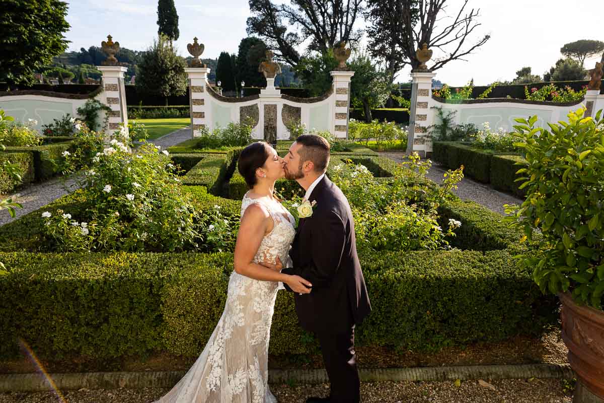 Newlyweds kissing on the beautiful Italian style gardens. Wedding Elopement Photographer in Tuscany 