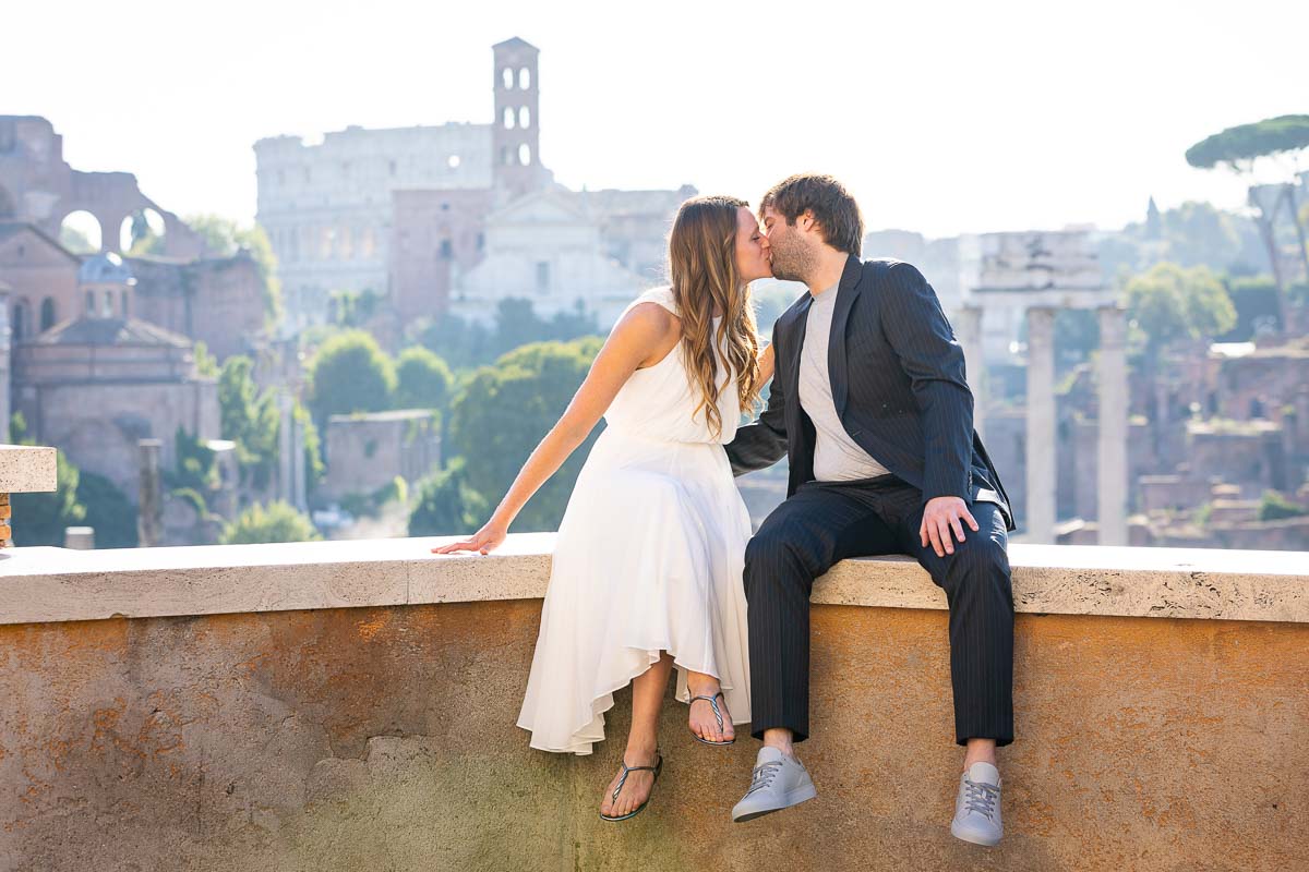 Couple kissing during a wedding photography service before the sweeping view of the roman ruins 