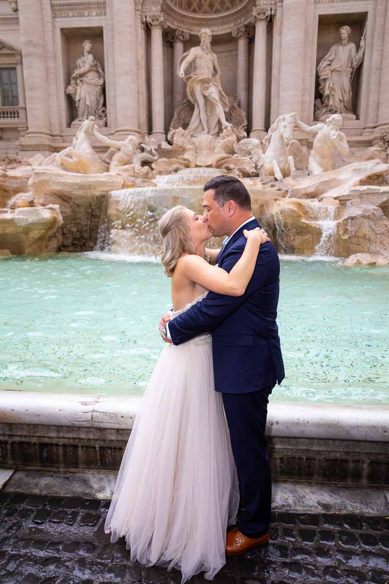 Newlywed couple kissing in front of the Trevi fountain