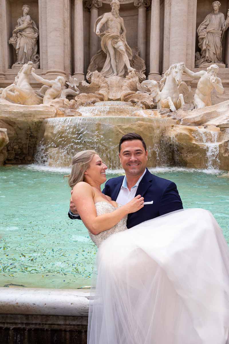 Groom picking up the bride to celebrate marriage in Rome Italy