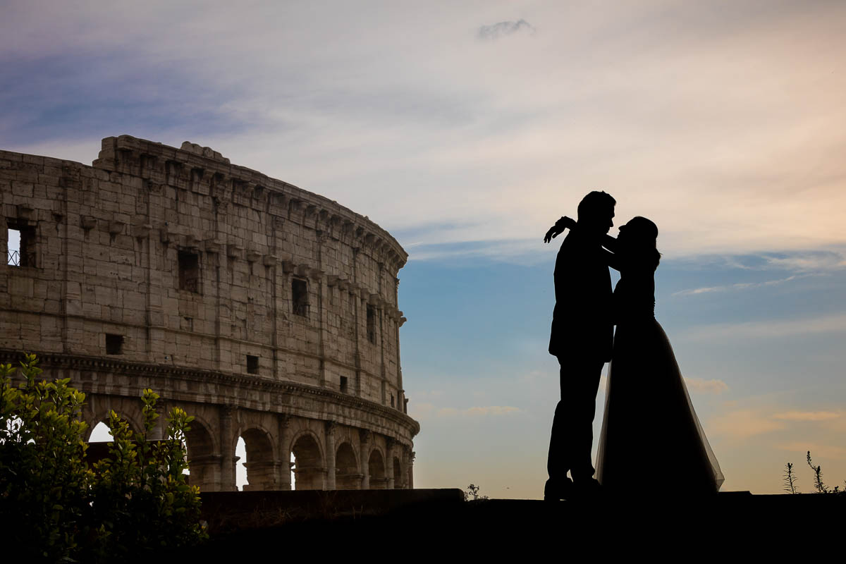 Newlyweds taking photos at the Roman Colosseum during a photo shoot