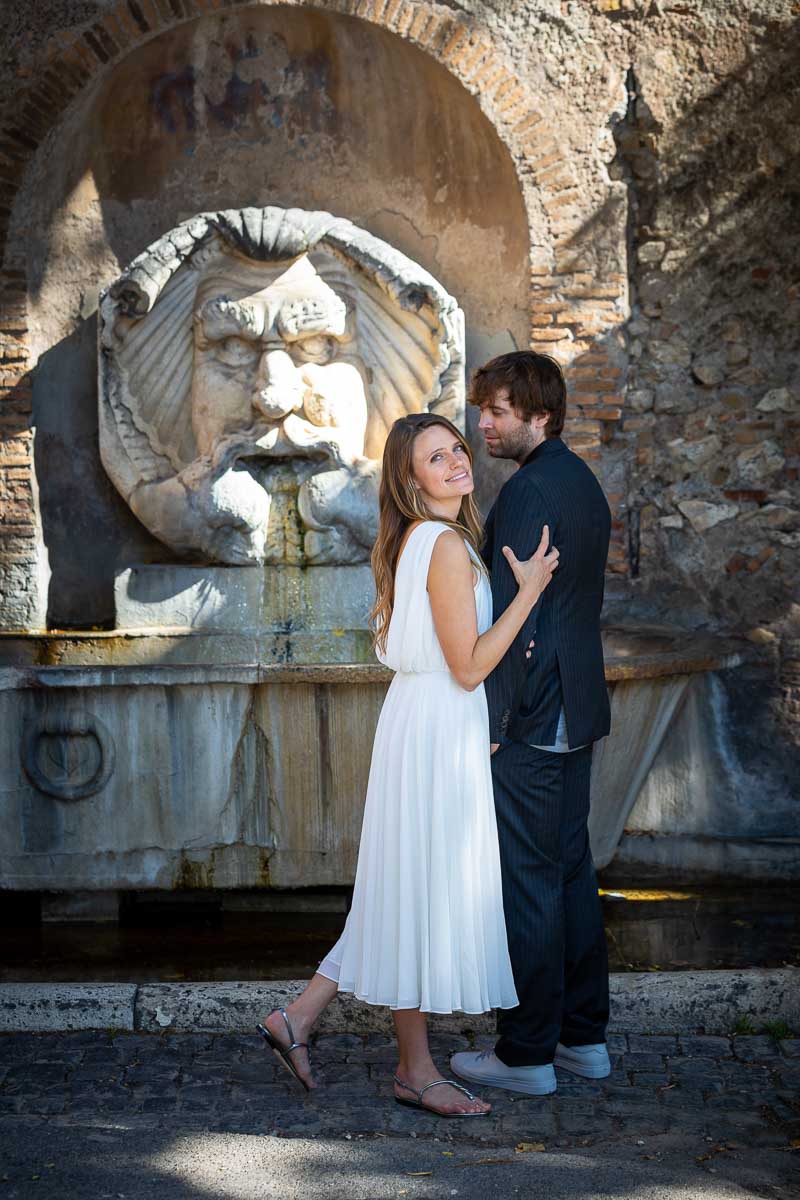 Couple picture pose in front of the marble water fountain found at the entrance of Rome' Giardino degli Aranci