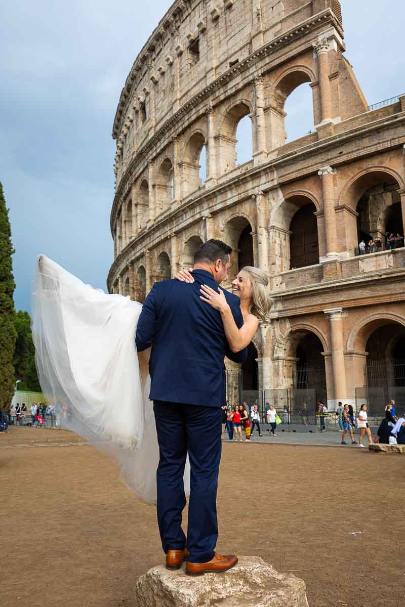 Groom picking up the bride in front of the Coliseum