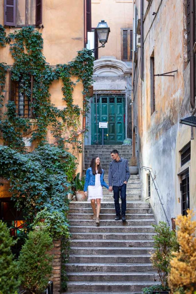 Couple walking hand in hand during an engagement photo shoot in the streets of Rome Italy