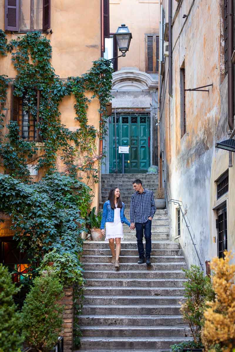 Couple walking hand in hand during an engagement photo shoot in the streets of Rome Italy