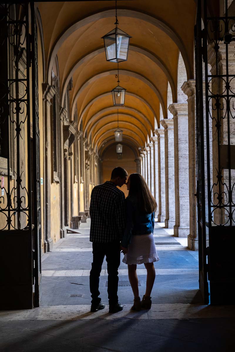 Silhouette image of a recently engaged couple posing by the cloister portico 