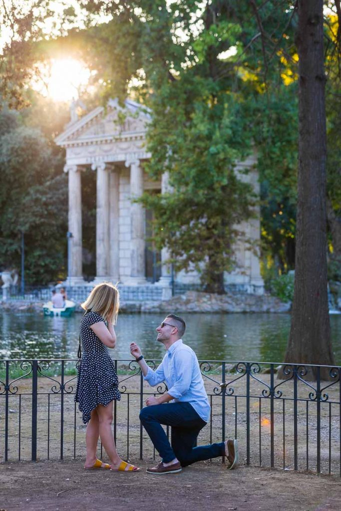 Lakeside wedding marriage proposal candidly photographed from a distance in Rome's Villa Borghese park