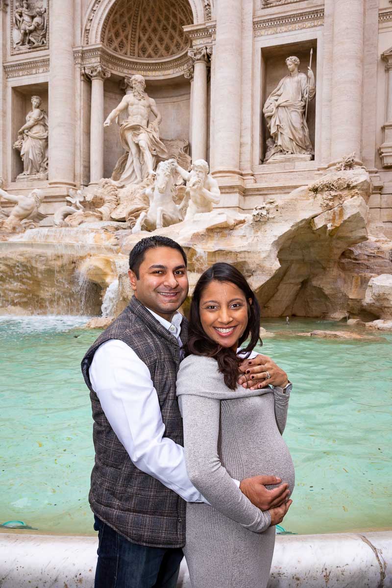 Couple posing during a pregnancy photoshoot in Rome at the Trevi fountain 