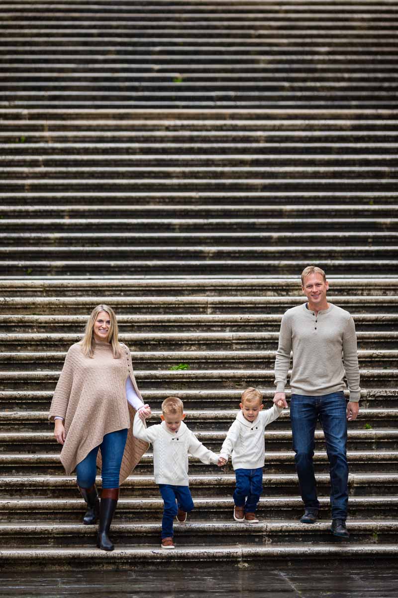 Family holding hands and descending staircase 