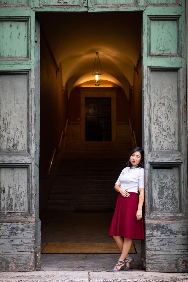 Standing underneath an ancient doorway female Rome model photography in nice natural light