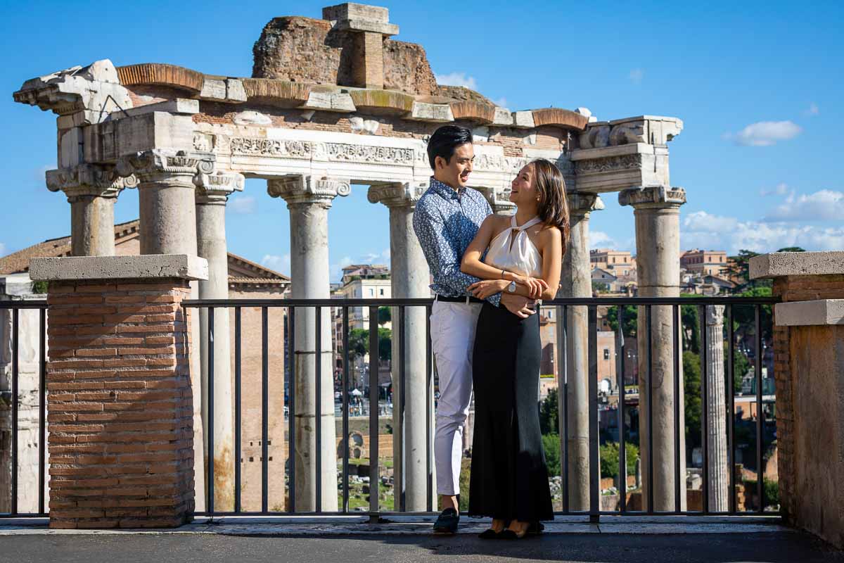 Together in Rome standing in front of the ancient Rome ruins of the imperial forum 