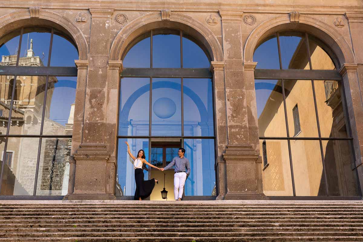 Standing on top of a large staircase posing for a photograph during a Rome couple photoshoot 