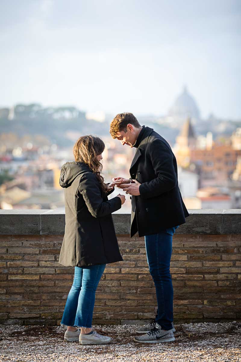 Just engaged. Putting the engagement ring on the hand before the fascinating roman view over the city