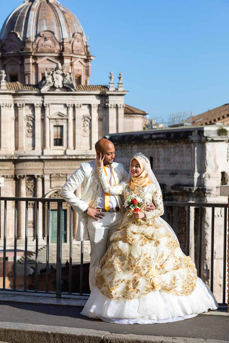 Just married couple posed in front of the ancient roman forum before ancient ruins