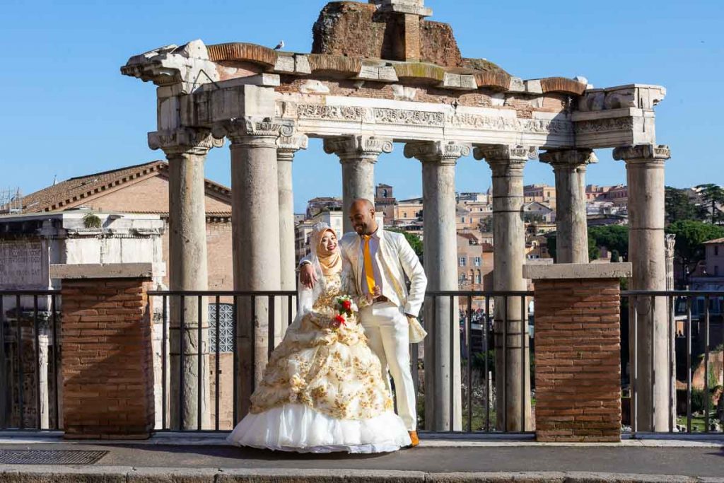 Groom and bride posing in front of the Roman Forum in Rome