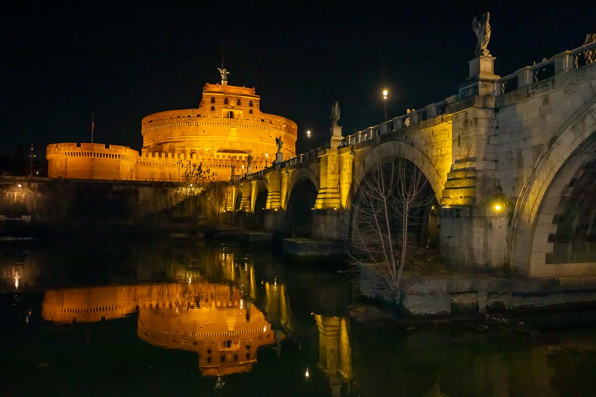 The Castel Sant'Angelo and bride seen at night from down below by the river tevere in Rome