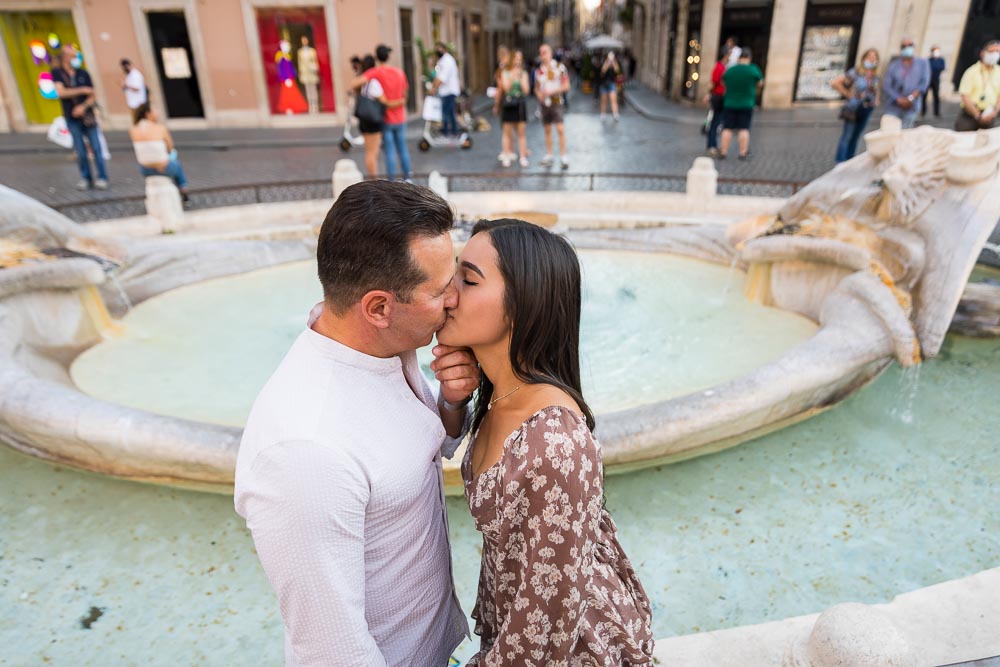 A romantic kiss taken by the water fountain found at the bottom of Piazza di Spagna