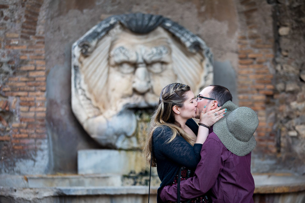 Kissing in front of an ancient marble statue 