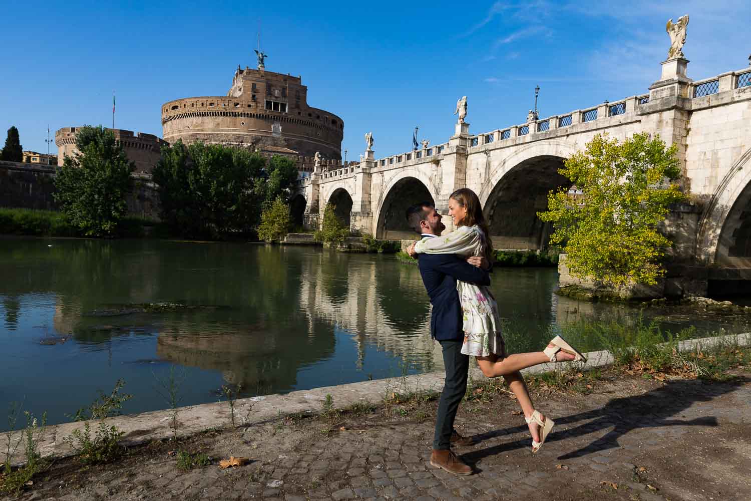 Jumping for joy at the Castel Sant'Angelo bridge next to the Tiber river bank 