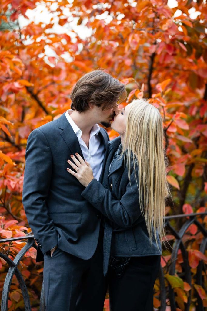 Couple kissing during an engagement photo session in autumn