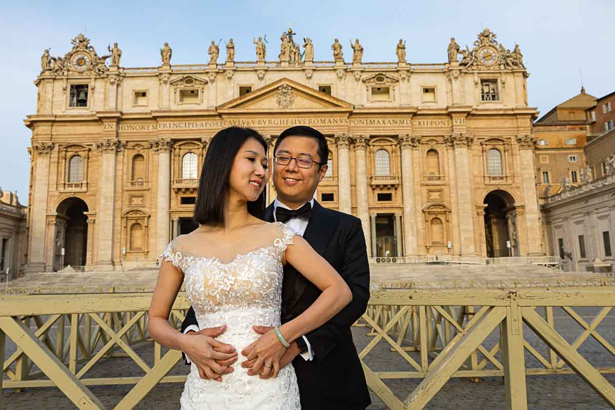 Smiling newlywed portrait snapped under the Basilica of San Pietro in Rome Italy 