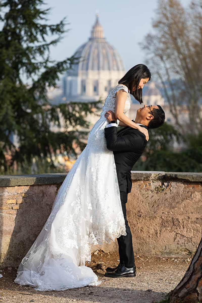 Groom picking up Bride in the sky with Saint Peter's dome in the far distance