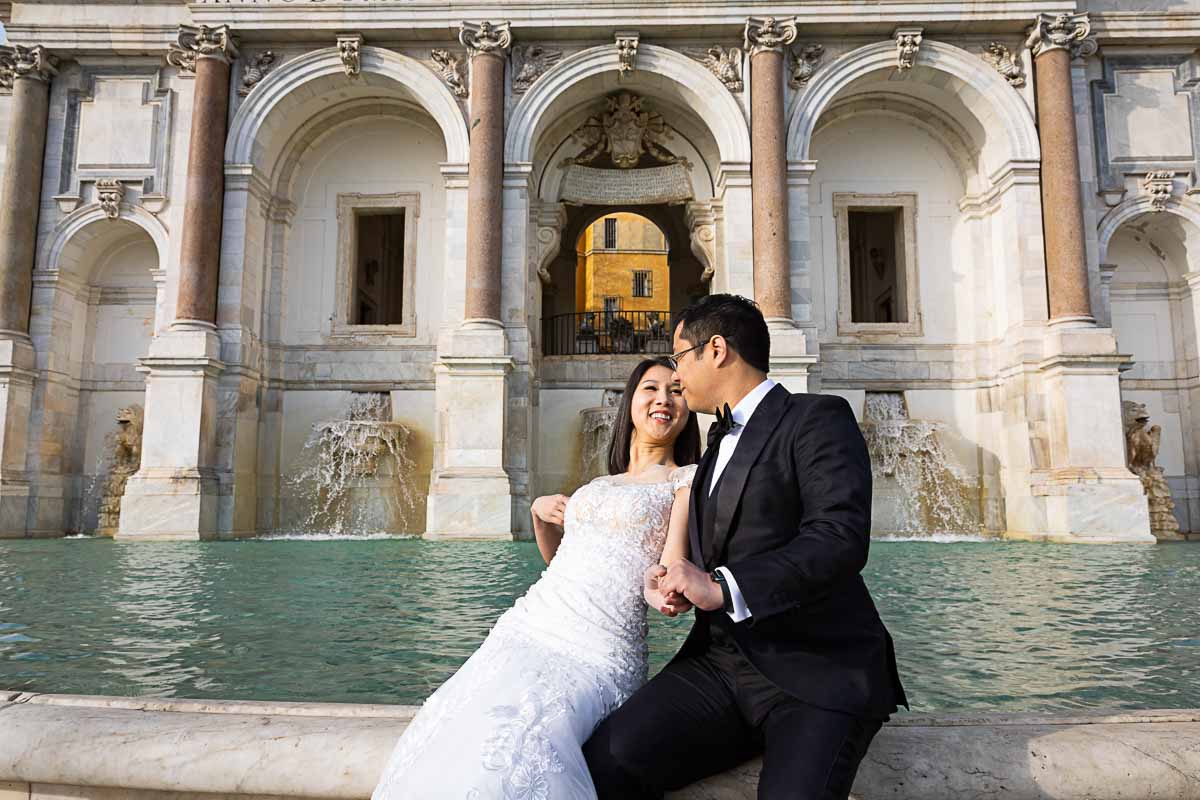 Newlywed sposi novelli taking pictures at the Fontanone water fountain in the city of Rome in Italy