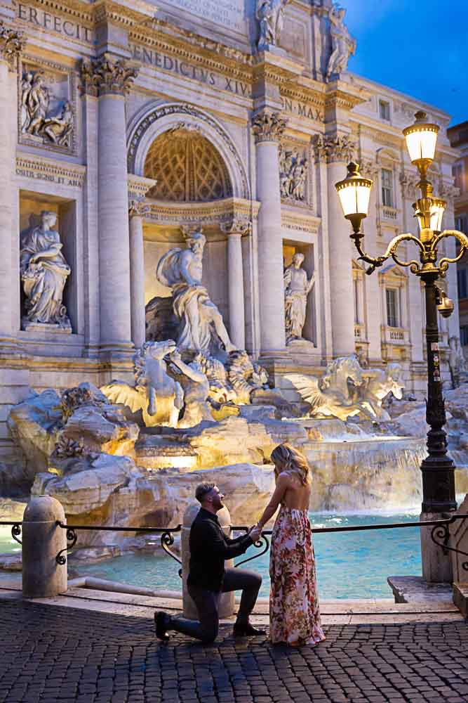 Asking the big question one knee down proposal at Trevi fountain in Rome Italy. Image taken in the early morning with the street lights still on
