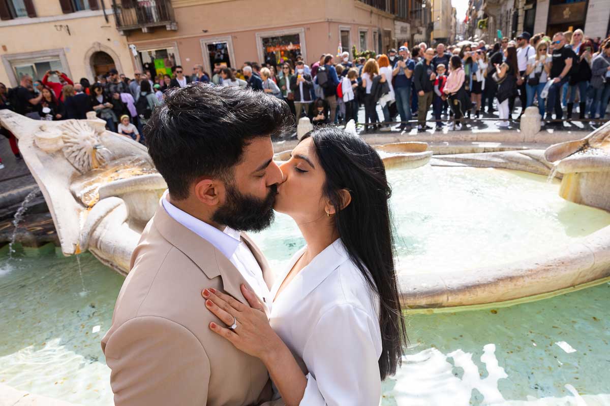 Coupe kissing by the Barcaccia water fountain in Rome Italy