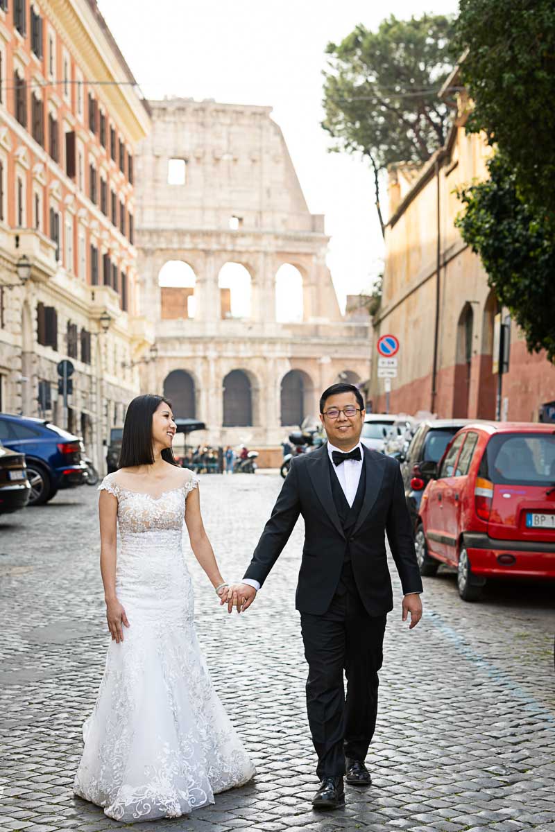 Couple just married walking hand in hand in the roman cobblestone streets and alleyways with a one of a kind background