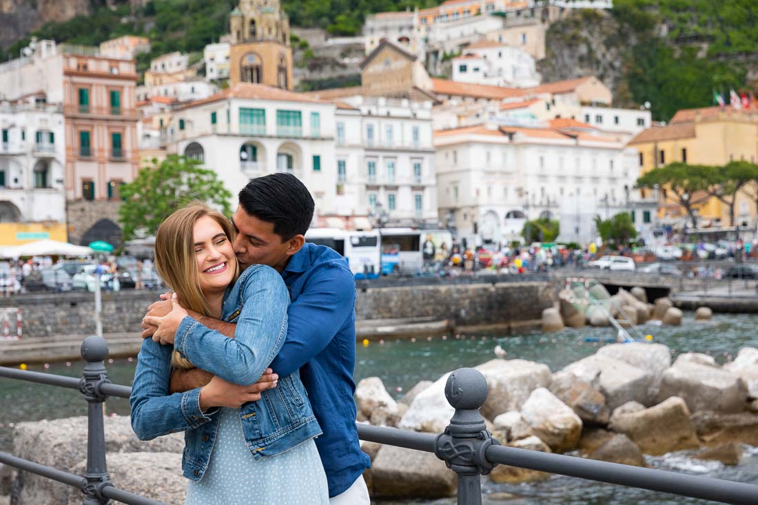 Together taking pictures on a pier overlooking the coastal town of Amalfi