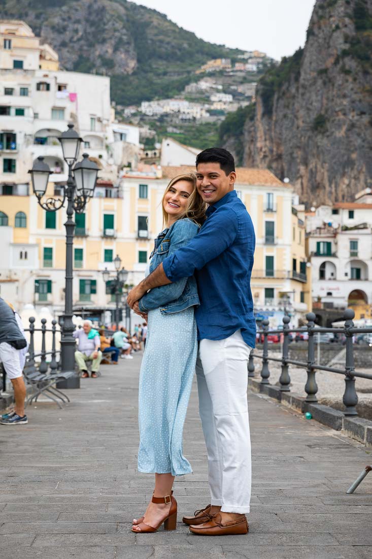 Couple posing on a pier with the town in the background