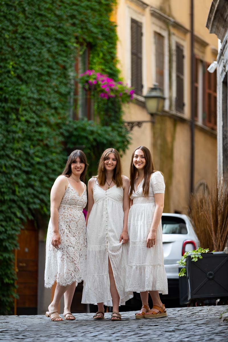 Group photo of three girls posing in the cobblestone streets of Rome Italy during a photography session in the off the beaten track corners of the city