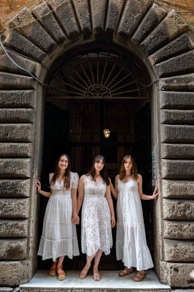 Stand up group portrait. In search of the best light. Posed underneath a doorway arch in Rome's alleyway streets