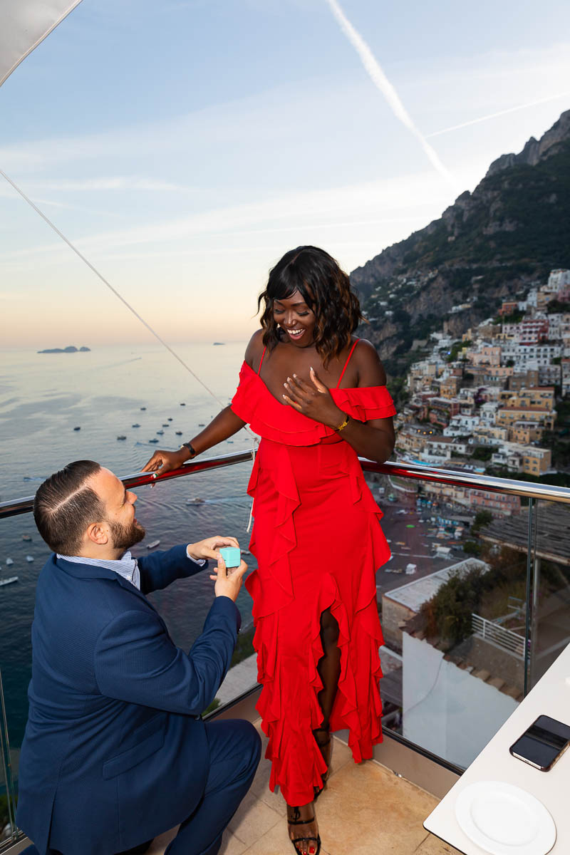 Knee down Positano Restaurant Wedding Proposal overlooking the beautiful coast in the far distance