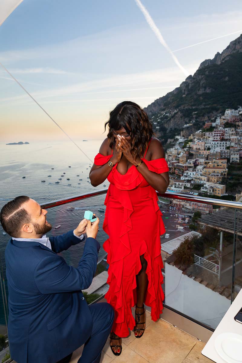 Surprised by a wedding proposal in Positano with a view of the coast and the town in the far distance