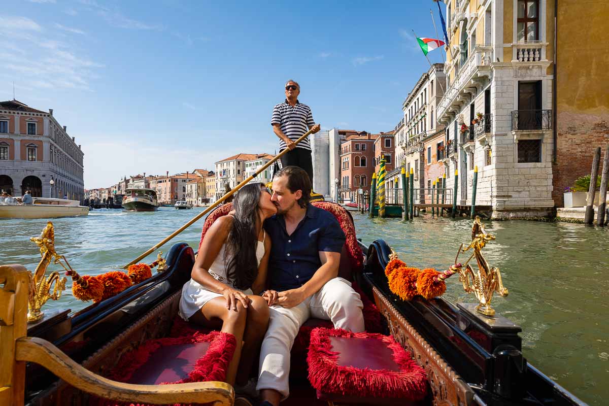 Kissing in Venice Italy on a gondola ride on Canal Grande after a romantic proposal 