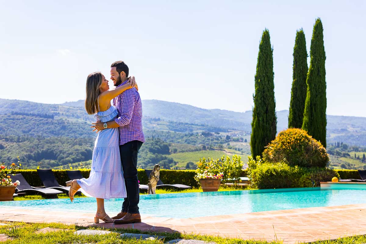 Coupe photography taken next to a swimming in Tuscany during an engagement photo session