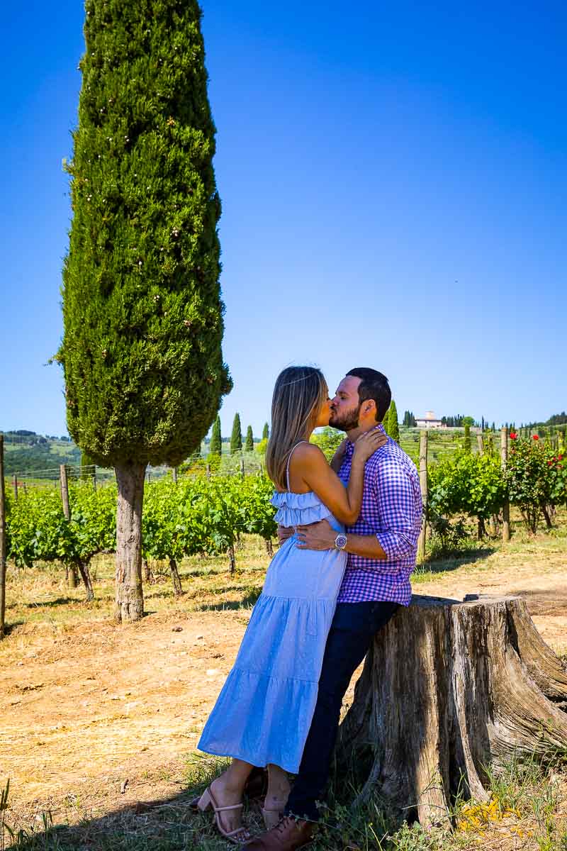Typical Tuscan Couple Photography taken with vineyards and cypress trees in the background under a beautiful blue sky 