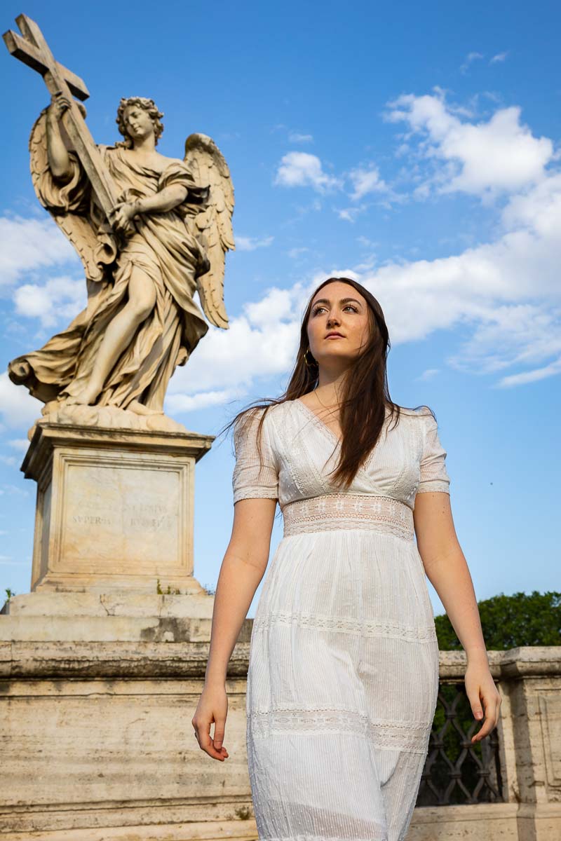 Model portrait three dynamic editorial portrait while looking sideways and upward with an angel statue in the background