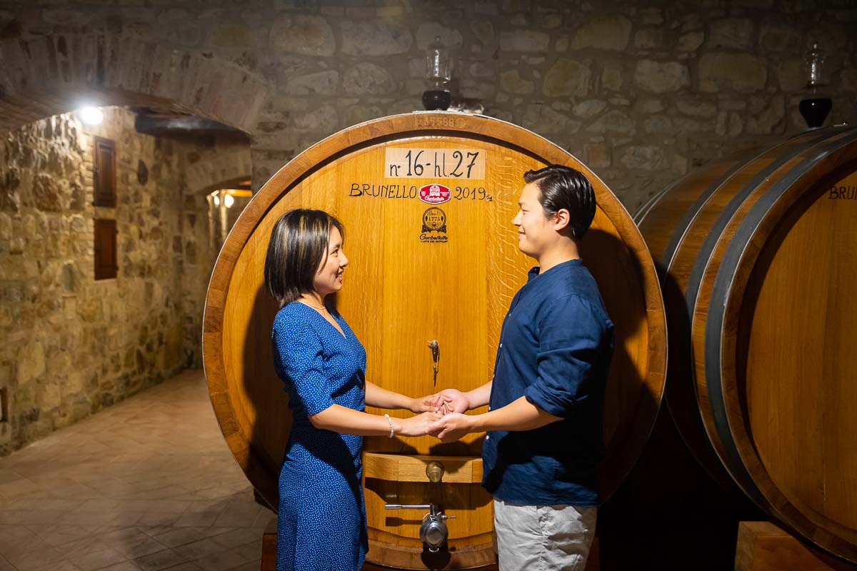 Hand in hand taking pictures in the wine cellar 